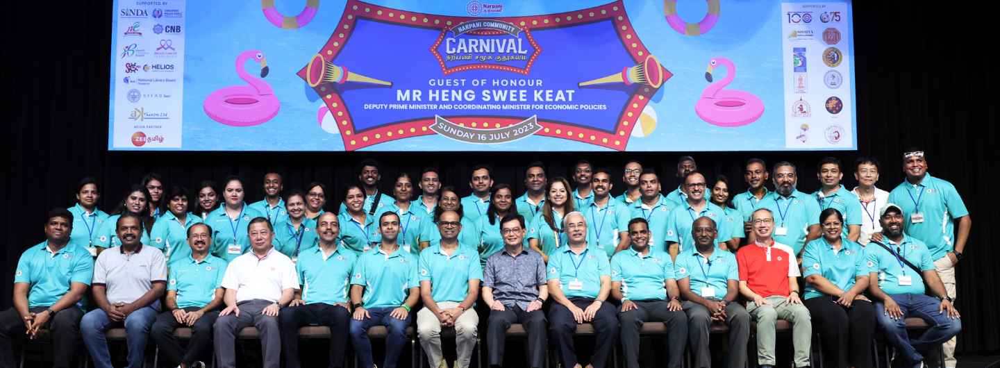 Large group poses in front of "Narpani Community Carnival" banner featuring Mr. Heng Swee Keat.